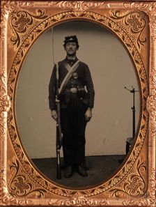 [Union Soldier Holding Rifle, with Photographer's Posing Stand], 1861-65. Creator: Unknown