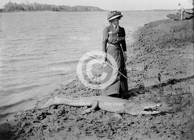 Unknown lady with rifle and a saltwater crocodile, 1910. Creator: Robert Augustus Henry L'Estrange.