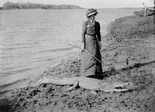 Unknown lady with rifle and a saltwater crocodile, 1910. Creator: Robert Augustus Henry L'Estrange