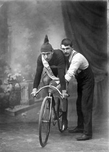 Unknown man on a bicycle, studio portrait (Championship of Queensland sash/ribbon), 1905. Creator: Robert Augustus Henry L'Estrange