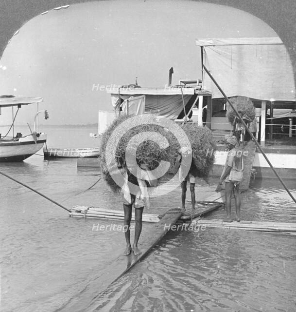 Unloading a vessel on the Irrawaddy River, Burma, 1908. Artist: Stereo Travel Co