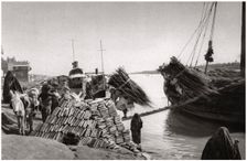 Unloading cargo from a boat, Muhaila, Baghdad, Iraq, 1925.Artist: A Kerim