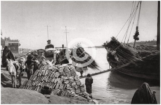 Unloading cargo from a boat, Muhaila, Baghdad, Iraq, 1925.Artist: A Kerim