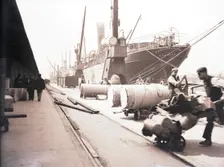 Unloading rolls of paper from a ship, London, c1905