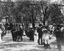 U.S. Naval Academy, Annapolis: 4 midshipmen carrying a man; crowd of guests along sidewalk, (1902?). Creator: Frances Benjamin Johnston