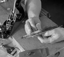 Using an adjustment gauge on a Stanley plane, 1968. Creator: Michael Walters