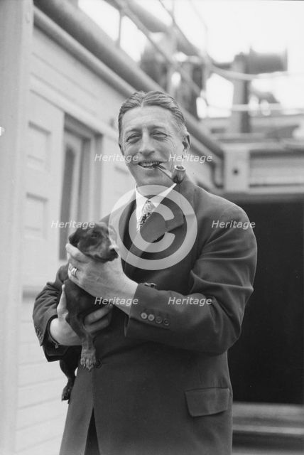 Von Lueckner, Felix, Count, with dog, standing outdoors, 1931 June 5. Creator: Arnold Genthe.