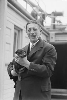 Von Lueckner, Felix, Count, with dog, standing outdoors, 1931 June 5. Creator: Arnold Genthe