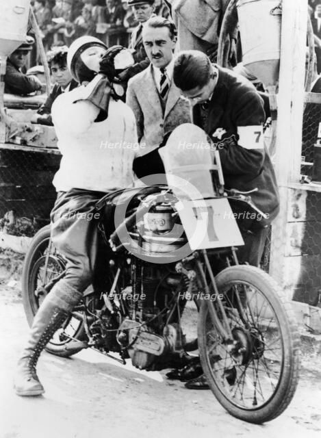 Van Horne taking a drink whilst on his Norton bike. Artist: Unknown