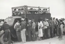 Vegetable pickers, migrants, waiting after work to be paid, near Homestead, Florida, February 1939. Creators: Farm Security Administration, Marion Post Wolcott