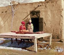 Vendors beside table displaying flatbread, between 1905 and 1915. Creator: Sergey Mikhaylovich Prokudin-Gorsky
