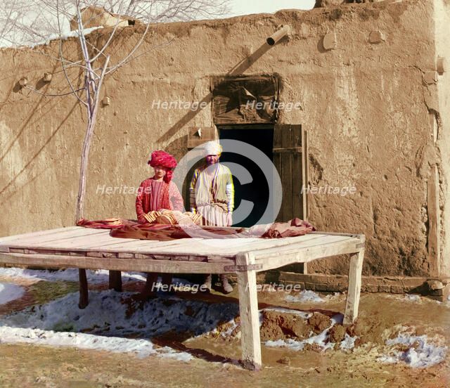Vendors beside table displaying flatbread, between 1905 and 1915. Creator: Sergey Mikhaylovich Prokudin-Gorsky.