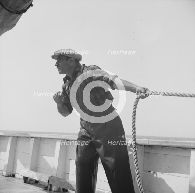 Vito Camella hollers for help to anchor a dory, Glocester, Massachusetts, 1943. Creator: Gordon Parks.