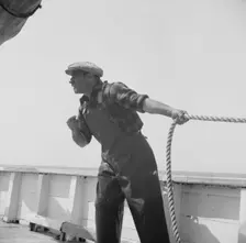 Vito Camella hollers for help to anchor a dory, Glocester, Massachusetts, 1943. Creator: Gordon Parks