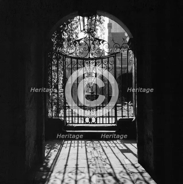 View through a decorative wrought iron gate in the Little Cloister at Westminster Abbey, 1946-1999. Creator: John Gay.