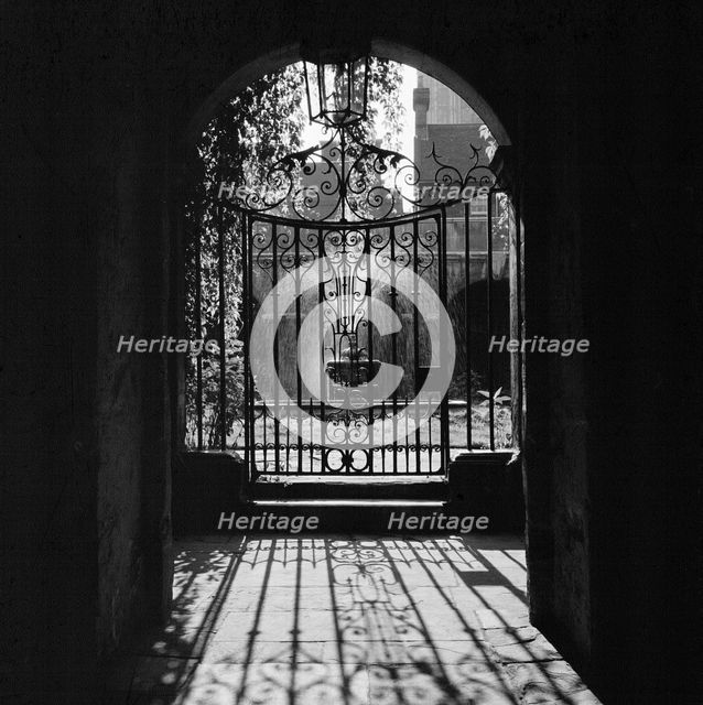 View through a decorative wrought iron gate in the Little Cloister at Westminster Abbey, 1946-1999. Creator: John Gay.