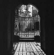 View through a decorative wrought iron gate in the Little Cloister at Westminster Abbey, 1946-1999. Creator: John Gay
