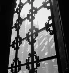 View through a wrought iron window grille towards the south facade of Westminster Abbey, 1947-57. Creator: John Gay