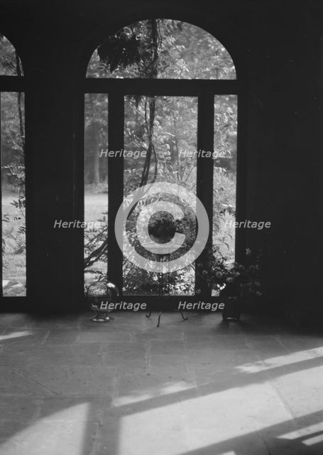 View through arched window into a courtyard, New Orleans or Charleston, South Carolina, c1920-c1926. Creator: Arnold Genthe.