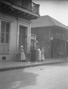 View from across street of four women talking, New Orleans, between 1920 and 1926. Creator: Arnold Genthe