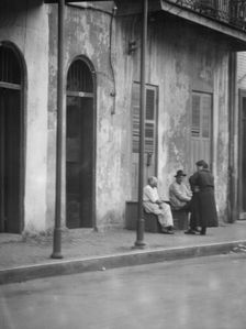 View from across street of people talking, New Orleans, between 1920 and 1926. Creator: Arnold Genthe
