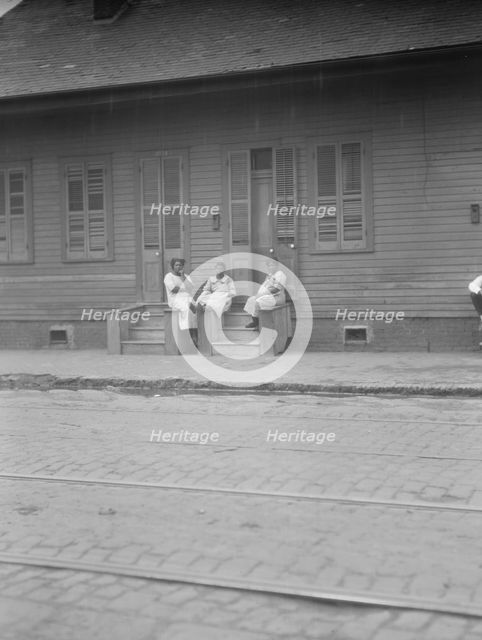 View from across street of three women talking, New Orleans or Charleston, South Ca., c1920-c1926. Creator: Arnold Genthe.