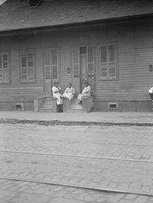 View from across street of three women talking, New Orleans or Charleston, South Ca., c1920-c1926. Creator: Arnold Genthe
