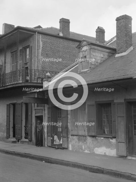 View from across street of two children standing in a doorway in the French Quarter..., c1920-1926. Creator: Arnold Genthe.