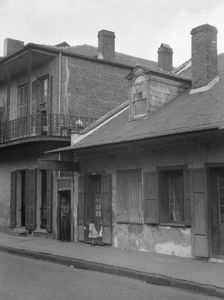 View from across street of two children standing in a doorway in the French Quarter..., c1920-1926. Creator: Arnold Genthe
