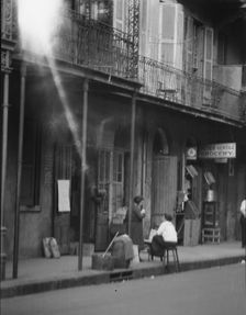 View from across street of two women talking, New Orleans, between 1920 and 1926. Creator: Arnold Genthe