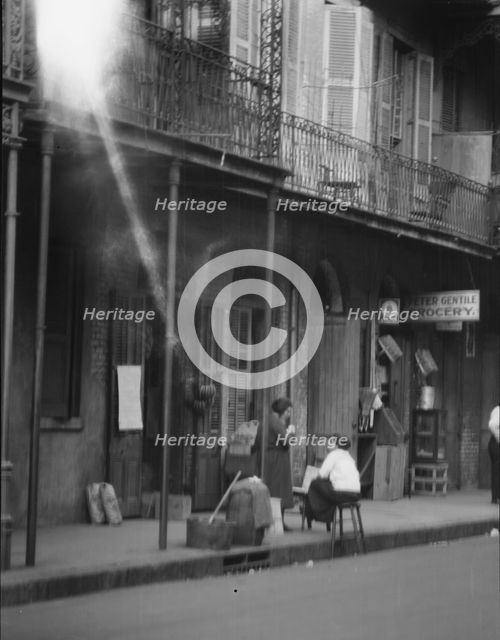 View from across street of two women talking, New Orleans, between 1920 and 1926. Creator: Arnold Genthe.