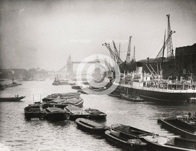 View of the busy Thames looking towards Tower Bridge, London, c1920. Artist: Unknown