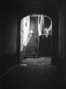 View of a courtyard through an arched passageway, New Orleans, between 1920 and 1926. Creator: Arnold Genthe