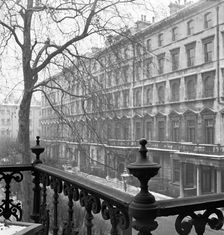 View of a lightly-snowy London square from a raised position behind a wrought-iron rail, 1947. Creator: John Gay