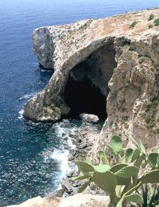 View of natural bridge and boat, Blue Grotto, Malta. Creator: Peter Thompson
