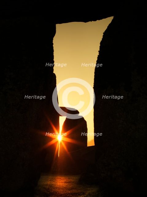 View of Stonehenge, showing the sun's rays glinting through the opening in a trilithon, 2012. Creator: James O Davies.