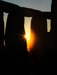 View of Stonehenge, showing the sun's rays glinting through the opening in a trilithon, 2012. Creator: James O Davies