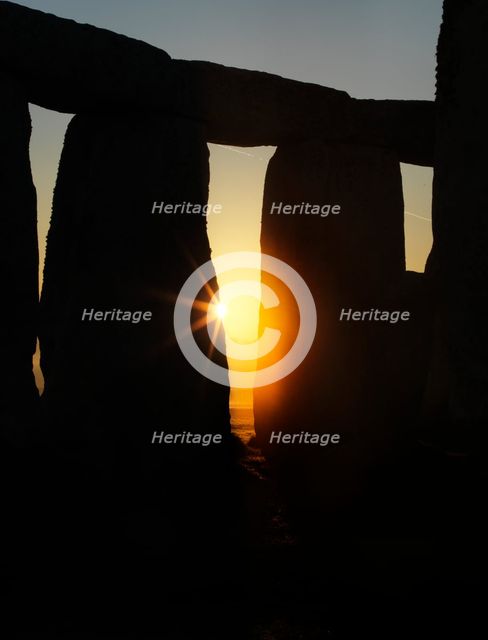 View of Stonehenge, showing the sun's rays glinting through the opening in a trilithon, 2012. Creator: James O Davies.
