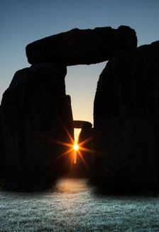 View of Stonehenge, showing the sun's rays glinting through the opening in a trilithon, 2012. Creator: James O Davies