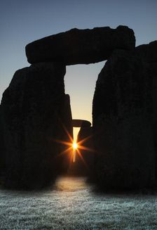 View of Stonehenge, showing the sun's rays glinting through the opening in a trilithon, 2012. Creator: James O Davies