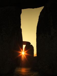 View of Stonehenge, showing the sun's rays glinting through the opening in a trilithon, 2012. Creator: James O Davies