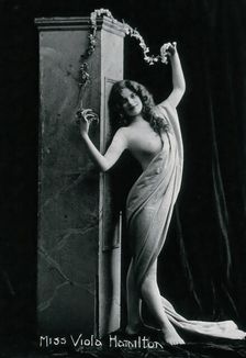 Viola Hamilton, posing in a classical attitude against a square column, early 20th century. Creator: Unknown