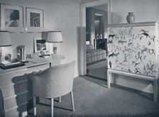 W. & J. Sloane. Photographer's hobby room showing a desk in natural oak, a hand-woven covering on t