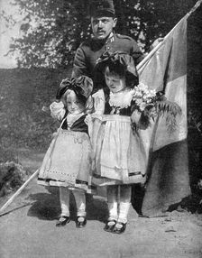 Young Alsatian children in traditional dress with a French soldier, World War I, 1915