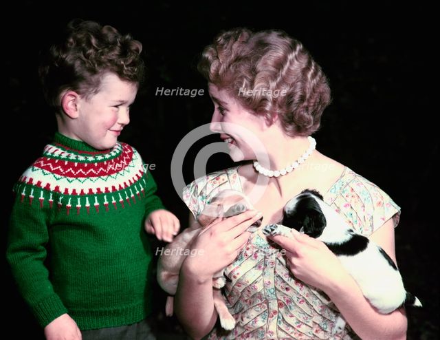 Young boy and woman holding two puppies, c1955-1965. Creator: Arthur Charles Kirby Ware.