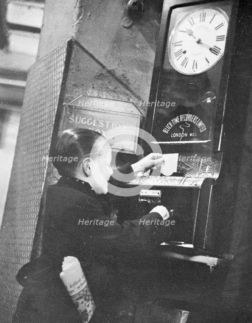 Young boy clocking on at the Trocadero Restaurant, Leicester Square, Westminster, London, c1939. Artist: Unknown