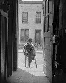 Young boy standing in the doorway of his home on Seaton Road...,Washington, D.C, 1942. Creator: Gordon Parks