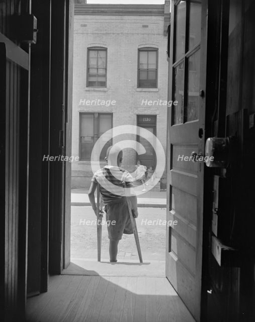 Young boy standing in the doorway of his home on Seaton Road...,Washington, D.C, 1942. Creator: Gordon Parks.