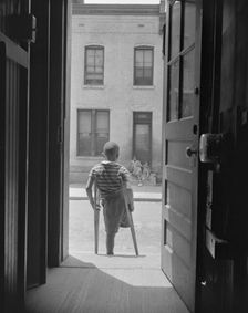 Young boy standing in the doorway of his home on Seaton Road...,Washington, D.C, 1942. Creator: Gordon Parks