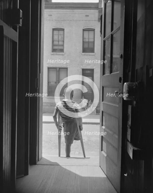 Young boy standing in the doorway of his home on Seaton Road...,Washington, D.C, 1942. Creator: Gordon Parks.